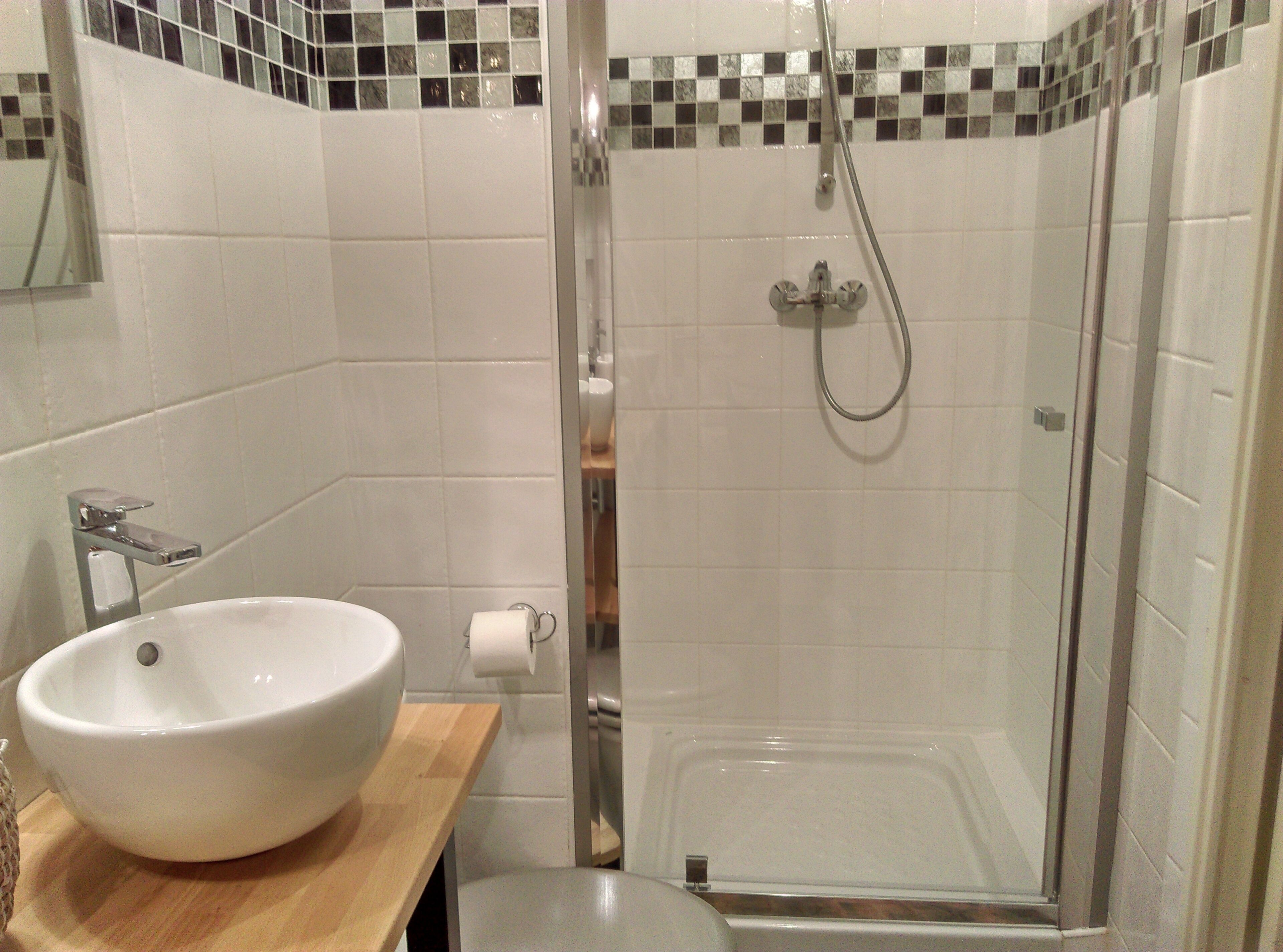 Une salle de bain avec un lavabo blanc, des toilettes et une cabine de douche.