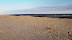 A wide sandy beach with a clear sky.