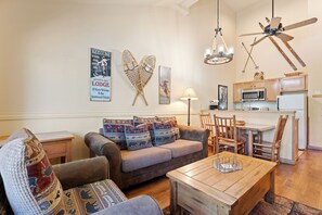 A cozy living room with a sofa, chairs, a coffee table, and a kitchen area with a microwave and refrigerator. - Beautiful Condo In Great Location With Hot Tub & Pool Openl!  (Keystone)