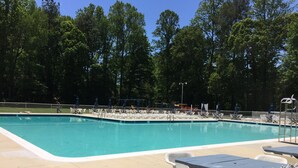 A rectangular swimming pool with a tiled edge, surrounded by a fence. There are lounge chairs and a table with a towel on it. - Waterfront Tranquil Escape-Single Family/Gated Community/Pool/Tennis Courts  (Lewes)