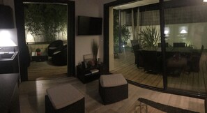 Un salon moderne avec une porte vitrée donnant sur un patio extérieur.