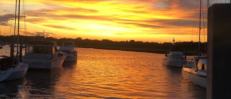 Vista del atardecer desde un barco, con varios otros barcos amarrados cerca.