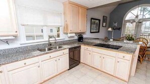 A kitchen with a granite countertop, white cabinets, a dishwasher, and a large window. - Great waterfront relaxation! (Bumpass)