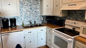 A kitchen with white cabinets, a built-in microwave, a stove, and a dishwasher. - 2 BR, 2 Bath, Oceanfront-First Floor-Condo A6-Dog Friendly-Wifi - NO-SMOKING! (North Myrtle Beach)