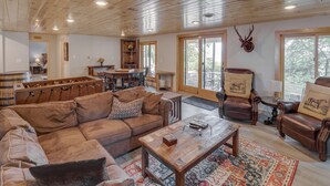 Ein geräumiges Wohnzimmer mit Holzboden, einer Couch, einem Couchtisch und Ledersesseln.