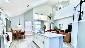 A spacious kitchen with a central island, wooden dining table, and white cabinetry. - 6 Bed/Pool/Spa/Internet/gameRoom, 3.5 Miles to Disney,Gated Resort communities (Kissimmee)