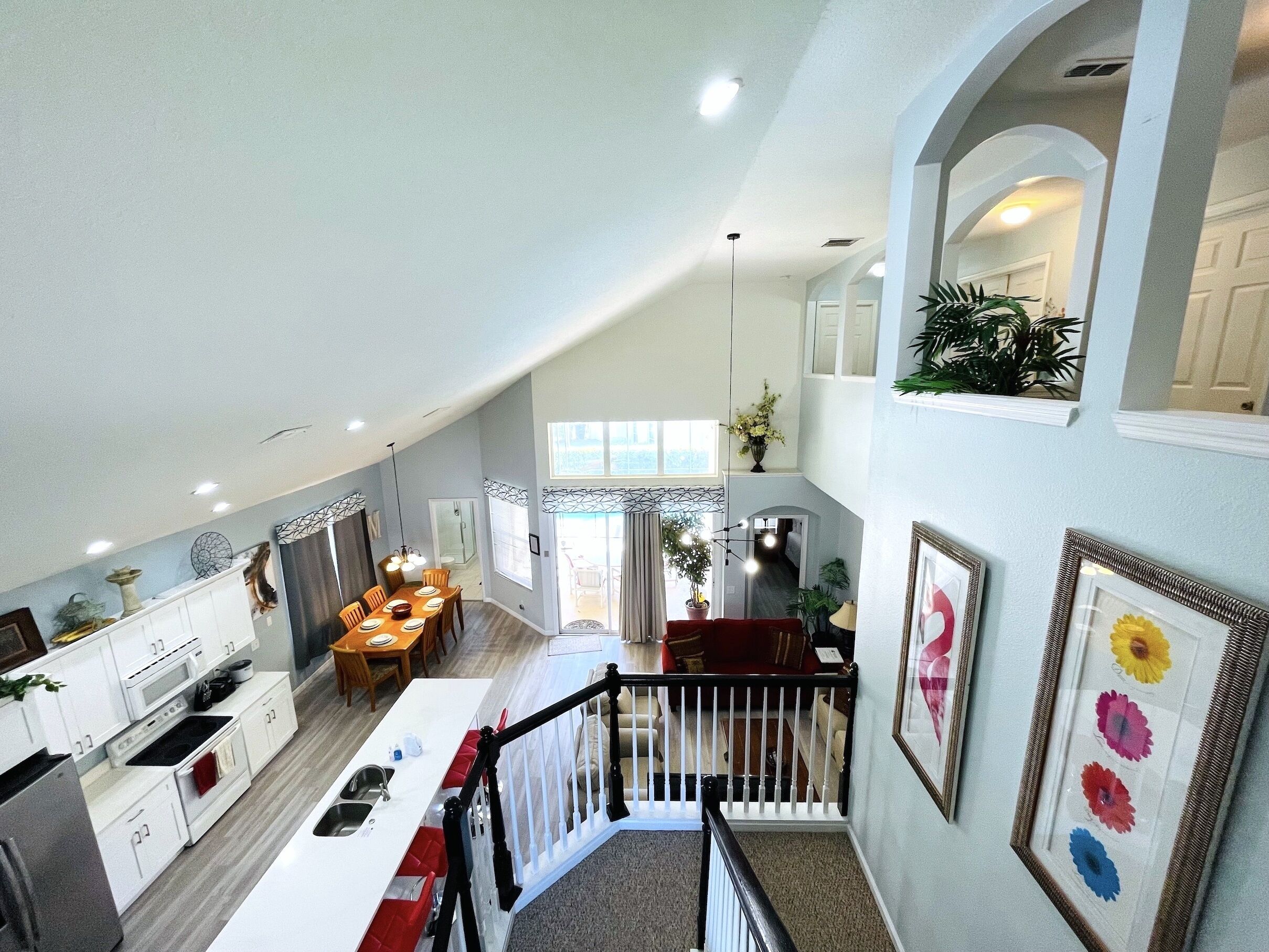 Un vaste loft comprenant une cuisine, un coin repas et un escalier menant à un deuxième étage.