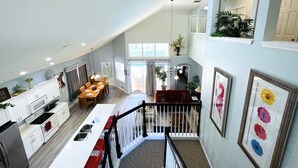 A spacious loft with a kitchen, dining area, and a staircase leading to a second floor. - 6 Bed/Pool/Spa/Internet/gameRoom, 3.5 Miles to Disney,Gated Resort communities (Kissimmee)