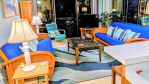 Een woonkamer met een bank, fauteuil, salontafel en lamp.