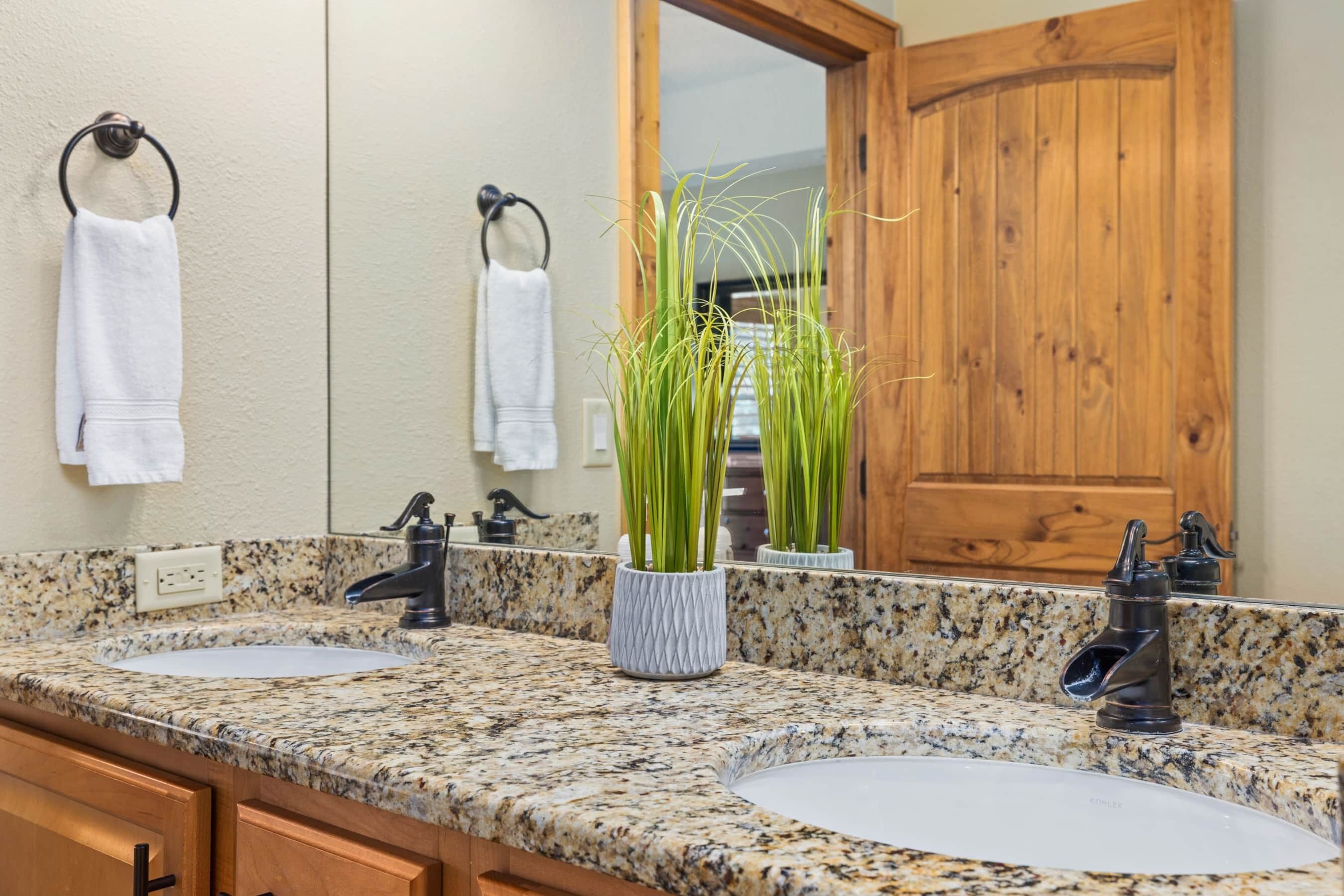 A bathroom with two sinks, a large mirror, and a wooden door.