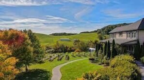 Stroll along the curved pathway to this traditional residence, surrounded by a well-manicured lawn and rolling hills.