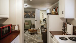 A compact kitchen with a microwave, stove, and a small dining area with a table and chairs.