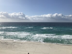 Une plage avec un rivage sablonneux et des vagues de l’océan.