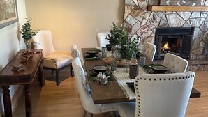 Un coin repas agrémenté d’un mur en pierre, d’une cheminée et d’un téléviseur fixé au-dessus.