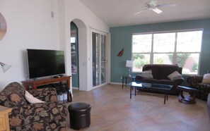 Relax in this inviting living room with a flat-screen TV, comfortable sofa, and glass coffee table.