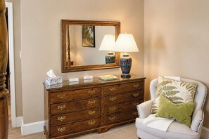 A room with a wooden dresser, a mirror, a lamp, a vase, a cushion, and a tissue box. - The Cary Cottage 1 BR 1 BA Private Sleeps 4 - Downtown Cary, Eat Drink Play Shop (Cary)