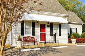 A white house with a red door, black shutters, and a red bench outside. - The Cary Cottage 1 BR 1 BA Private Sleeps 4 - Downtown Cary, Eat Drink Play Shop (Cary)