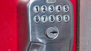A metallic door lock with a numeric keypad and a round handle.