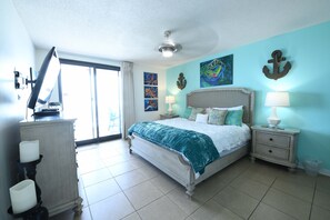 Relax in comfort with a large bed, ceiling fan, and artworks adorning the walls.