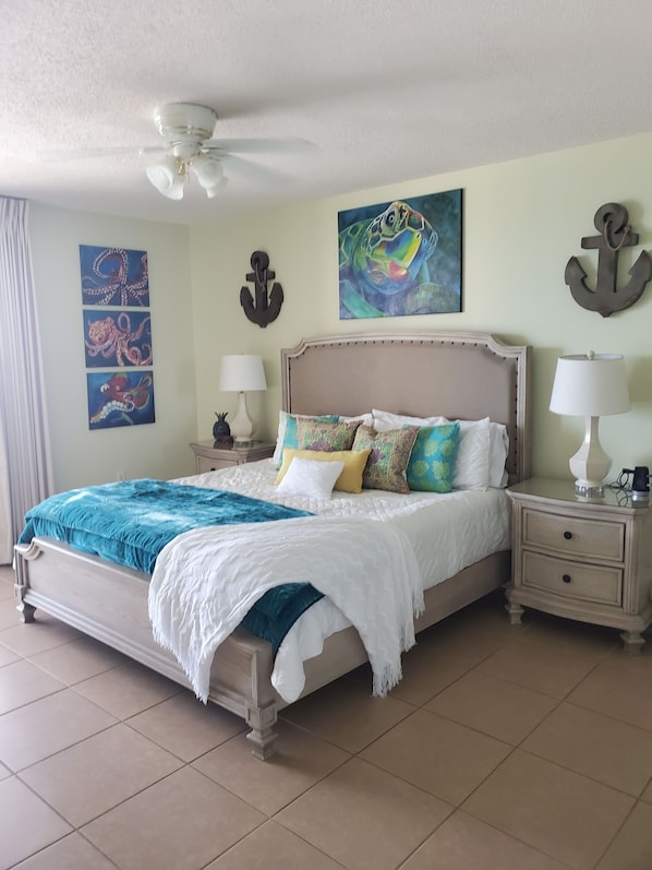 Classic bedroom with a large bed, two bedside tables, and artwork adorns the walls.