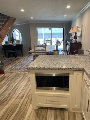Enjoy cooking in this well-equipped kitchen with a granite countertop, microwave, and ample dining space.