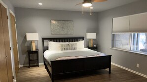 A bedroom with a bed, two bedside tables, a ceiling fan, a window, and a wall-mounted artwork. - 3/2
1 Mile to Main St! (Fredericksburg)