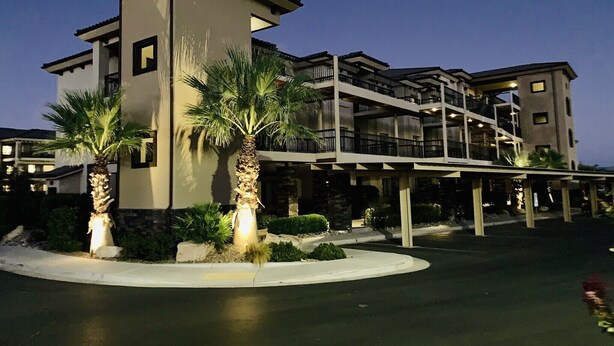 A multi-story hotel with a modern architectural design, featuring balconies and a covered walkway.