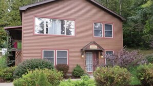 A two-story house with a brown exterior, a front porch, and a sign indicating it is the 'SOUTH' unit. - The Lily Pad at Loon Lake near Gore Mountain (Chestertown)