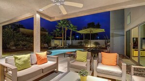 An outdoor patio area with a pool, seating, and a ceiling fan. - Cool Modern Pool & Spa, 2 Bedroom + Private Den House. (Palm Springs)