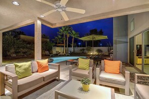 An outdoor patio area with a pool, seating, and a ceiling fan. - Cool Modern Pool & Spa, 2 Bedroom + Private Den House. (Palm Springs)