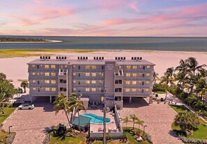 A multi-story hotel with a pool and a beach view.
