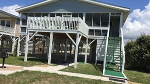 A two-story house with a balcony and a covered porch area. -  @ Ocean Front Guest Friendly Home "An Emerald On The Beach" (Sunset Beach)