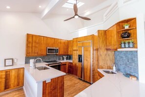 A modern kitchen with wooden cabinetry, stainless steel appliances, and a central island.