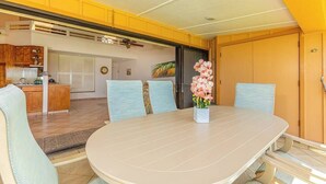A dining area with a round table, chairs, and a vase of flowers.