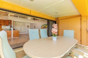 A dining area with a round table, chairs, and a vase of flowers.