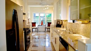 A modern kitchen with granite countertops, stainless steel appliances, and a dishwasher. - Refuge in the heart of Montrose (Houston)