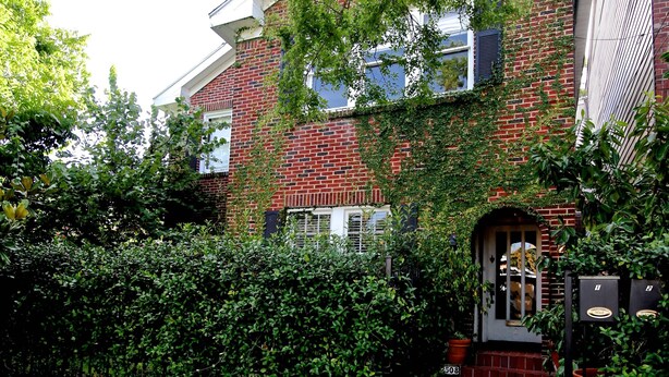A brick house with a front yard, a mailbox, and a door with a number plate. - Refuge in the heart of Montrose (Houston)