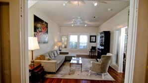 A living room with a sofa, armchairs, a coffee table, and a painting on the wall. - Refuge in the heart of Montrose (Houston)