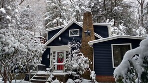 A two-story house with a red door and a chimney. - Serene Mountain Cottage on banks of McCullen Run Stream (Ligonier)