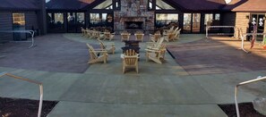 A lodge with a stone fireplace, outdoor seating, and a covered patio.