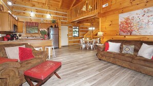 Una cabaña de madera espaciosa con cocina, comedor y sala de estar.