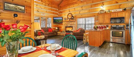 A cozy log cabin interior with a dining area, kitchen, and living room.