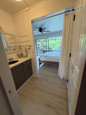 A bathroom with a mirror, towel rack, and a ceiling fan. - Prince Kuhio Poipu ~ Ocean View, quiet, comfortable, end unit-ground floor (Koloa)