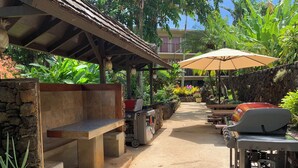 An outdoor patio with a barbecue grill, seating area, and a gas tank. - Prince Kuhio Poipu ~ Ocean View, quiet, comfortable, end unit-ground floor (Koloa)