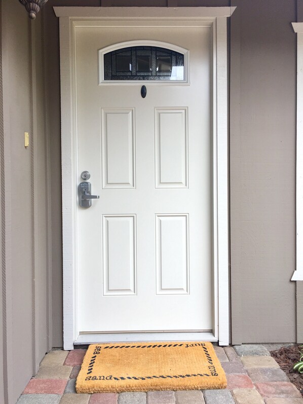 A white door with a rectangular glass panel and a doorknob.