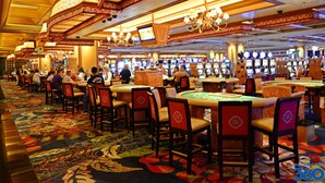 A casino with multiple gaming tables and chairs, a patterned carpet, and ornate ceiling decorations. - Blue Beach House, GAME ROOM, Sleep 8, Swim Pool, Gated, Casinos (Gulfport)