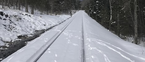 A snow-covered railway track with trees on either side.