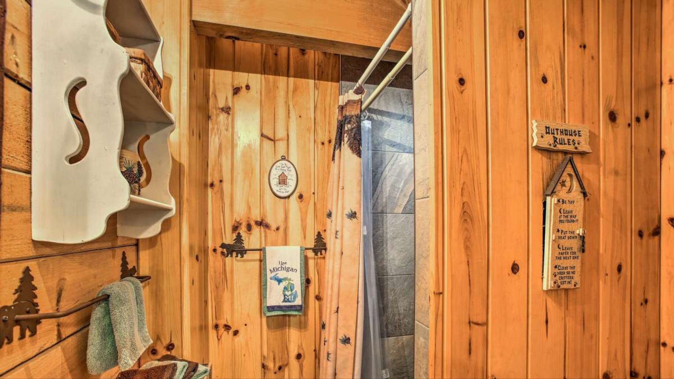 Un intérieur en bois, avec une porte en bois, un porte-serviettes et un panneau indiquant les règles.