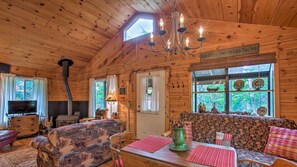 Relax in this cabin-style room with a comfortable sofa, dining table, and fireplace.