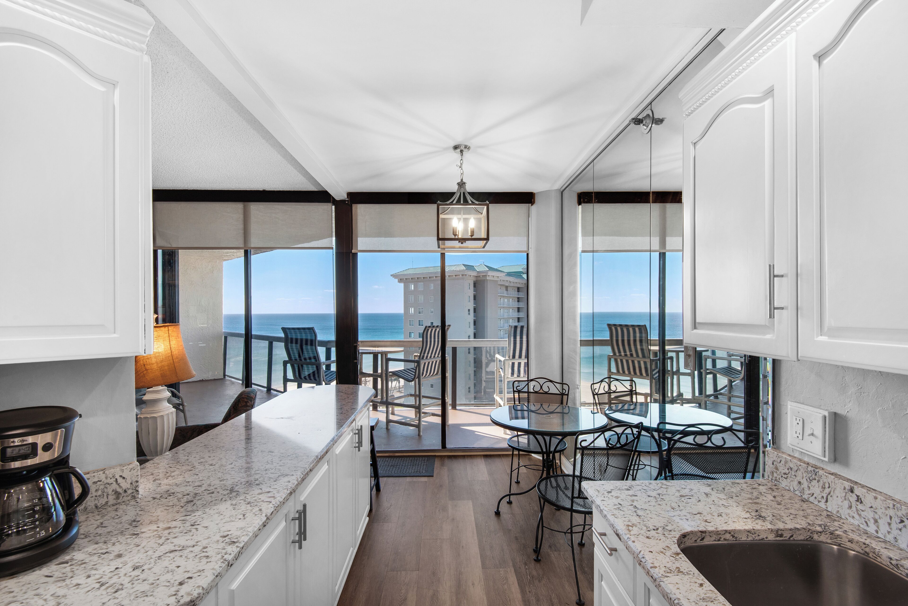 Una cucina con vista sull'oceano, una zona pranzo con sedie e un'ampia finestra.
